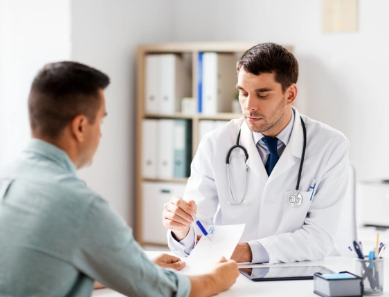 General physician discussing symptoms and treatment options with a patient during a routine primary care consultation.