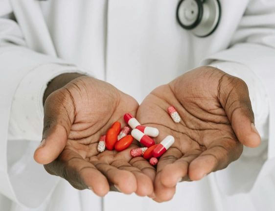 Internal medicine doctor discussing symptoms, medications, and treatment options with an adult patient during a comprehensive health evaluation.