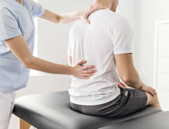 Orthopedic specialist evaluating a patient's knee, joints, and mobility during a musculoskeletal examination.